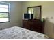 Bedroom with dresser, TV, and large window with view at 929 Capri Isles Blvd # 22, Venice, FL 34292