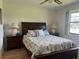 Bright bedroom with double bed and wood furniture at 929 Capri Isles Blvd # 22, Venice, FL 34292