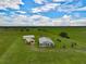 Aerial view of home, detached garage, and pasture at 27000 Harrison Rd, Sidell, FL 34266