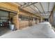 Well-lit barn aisle with multiple horse stalls at 27000 Harrison Rd, Sidell, FL 34266