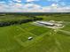 Aerial view of expansive equestrian property with multiple barns and paddocks at 27000 Harrison Rd, Sidell, FL 34266