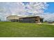 Two metal barns, one with screened patio; grassy area at 27000 Harrison Rd, Sidell, FL 34266