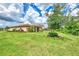 Landscaped backyard with lush lawn and mature trees at 12261 Canavese Ln, Venice, FL 34293