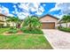 Single-story house with brown garage door, landscaping, and brick paver driveway at 12261 Canavese Ln, Venice, FL 34293