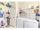 Well-organized laundry room with washer, dryer, and ample shelving at 12261 Canavese Ln, Venice, FL 34293
