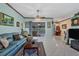 Spacious living room with teal couches and view of the dining area at 12004 Sarto Ln, North Port, FL 34287