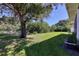 Large backyard with lush grass, mature trees, and a shed at 12004 Sarto Ln, North Port, FL 34287