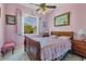 Bedroom with a wooden sleigh bed and pink color scheme at 12004 Sarto Ln, North Port, FL 34287