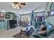 Spacious living room with teal couches, dining area, and tiled floors at 12004 Sarto Ln, North Port, FL 34287