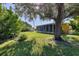 Landscaped backyard with a screened enclosure and large oak tree at 12004 Sarto Ln, North Port, FL 34287
