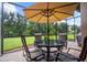 Enjoy al fresco dining in this screened patio, complete with table, chairs, and umbrella at 19866 Benissimo Dr, Venice, FL 34293