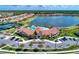Aerial view of a community clubhouse, pool, and lake surrounded by beautiful homes and landscaping at 12000 Tapestry Ln, Venice, FL 34293