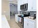 Bright kitchen featuring stainless steel appliances, white cabinetry, and mosaic backsplash at 12000 Tapestry Ln, Venice, FL 34293