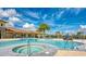 Beautiful community pool and jacuzzi surrounded by palm trees, lounge chairs, and landscaped areas at 12000 Tapestry Ln, Venice, FL 34293