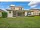 Two-story house with a screened-in porch and grassy backyard at 12232 Stuart Dr, Venice, FL 34293