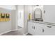 Well-lit bathroom vanity with granite counters, modern lighting, and a glimpse into a spacious glass-enclosed shower at 2228 Lynx Run, North Port, FL 34288