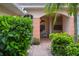 Charming villa entrance with brick pathway, lush landscaping, and arched doorway at 2228 Lynx Run, North Port, FL 34288