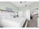 Bright main bedroom with a decorative headboard, a painting on the wall, and an open doorway to the kitchen at 2228 Lynx Run, North Port, FL 34288