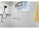 Shower stall featuring white tiling, a frosted window for privacy, and a modern shower head with a convenient grab bar at 2228 Lynx Run, North Port, FL 34288