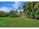 Well maintained front yard with lush green grass and tropical landscaping at 5103 Greencroft Rd, Sarasota, FL 34235
