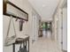 Bright hallway with tile floors, coat rack, and doorways leading to various rooms at 5103 Greencroft Rd, Sarasota, FL 34235