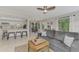 Open concept living room featuring a gray sofa, tile floors, and eat-in kitchen at 5103 Greencroft Rd, Sarasota, FL 34235