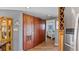Bright hallway with wood floors, linen closet, and access to bedroom at 1401 S Mccall Rd # 107B, Englewood, FL 34223