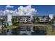 Condo building exterior with pond reflection and lush landscaping at 1401 S Mccall Rd # 107B, Englewood, FL 34223