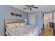 Bedroom with a floral comforter, ceiling fan, and bathroom access at 1401 S Mccall Rd # 107B, Englewood, FL 34223
