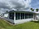 White single-wide manufactured home with large windows and a green lawn at 200 Roma Rd, Venice, FL 34285