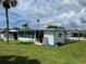 Side view of a mobile home with a spacious lawn at 200 Roma Rd, Venice, FL 34285