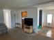 Living room with TV, entryway, and open view to kitchen at 200 Roma Rd, Venice, FL 34285