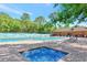 Community pool and spa with lounge chairs at 5103 Greencroft Rd # 24, Sarasota, FL 34235