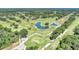 Aerial view of a golf course community with lush landscaping and a pond at 5103 Greencroft Rd, Sarasota, FL 34235