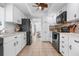 White kitchen with black appliances, tile floors, and ample counter space at 1009 Tam O Shanter Ct, Venice, FL 34293