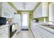 Long galley kitchen with white cabinets and stainless steel appliances at 475 Circlewood Dr # O18, Venice, FL 34293