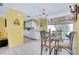 Bright dining area with glass table and four chairs, adjacent to kitchen at 475 Circlewood Dr # O18, Venice, FL 34293