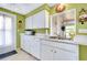 White kitchen cabinets, stainless steel sink, and view into adjoining room at 475 Circlewood Dr # O18, Venice, FL 34293