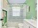 Clean bathroom with shower/tub combo, white vanity, and green walls at 475 Circlewood Dr # O18, Venice, FL 34293