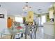 Dining area with glass table and chairs, view into kitchen and living room at 475 Circlewood Dr # O18, Venice, FL 34293