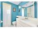 Bathroom with shower, white vanity, and blue walls at 475 Circlewood Dr # O18, Venice, FL 34293