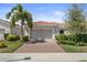 One-story house with tile roof, a two-car garage, and well-manicured landscaping at 12000 Tapestry Ln, Venice, FL 34293