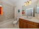Clean bathroom with a tub, toilet and wooden vanity at 117 Savona Way, North Venice, FL 34275