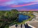 Scenic aerial view of community homes surrounding a serene lake under a colorful sky at sunset at 1586 Monarch Dr # 1586, Venice, FL 34293
