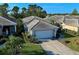 Well-maintained home with a tiled roof, two-car garage, and lush landscaping at 1586 Monarch Dr # 1586, Venice, FL 34293