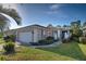 Inviting home features a two-car garage, screened entryway, and manicured landscaping at 1586 Monarch Dr # 1586, Venice, FL 34293