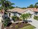 Charming single-story home featuring lush tropical landscaping, a tile roof, and a welcoming two-car garage at 277 Mestre Pl, North Venice, FL 34275