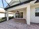Expansive brick paved patio with ceiling fan offers views of screened in lanai and backyard at 277 Mestre Pl, North Venice, FL 34275