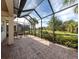 Spacious screened patio with brick pavers offers serene views of the lush backyard at 277 Mestre Pl, North Venice, FL 34275