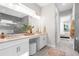 This bath offers granite counters, a double sink vanity and decorative mirror and is adjacent to the main bedroom at 8209 Redonda Loop, Lakewood Ranch, FL 34202